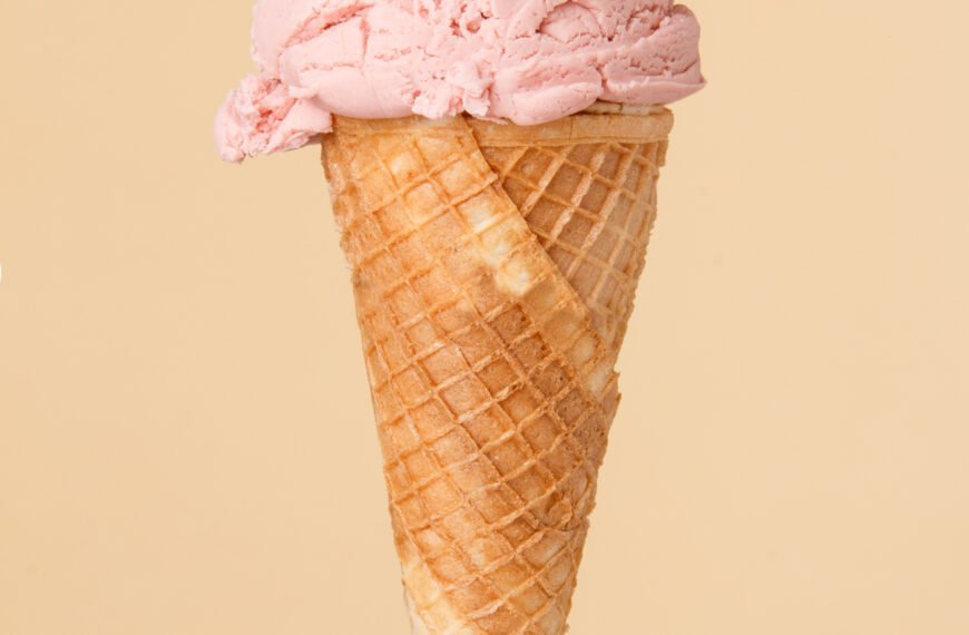 Cornet ice cream with a strawberry scoop on a colorful backgroun