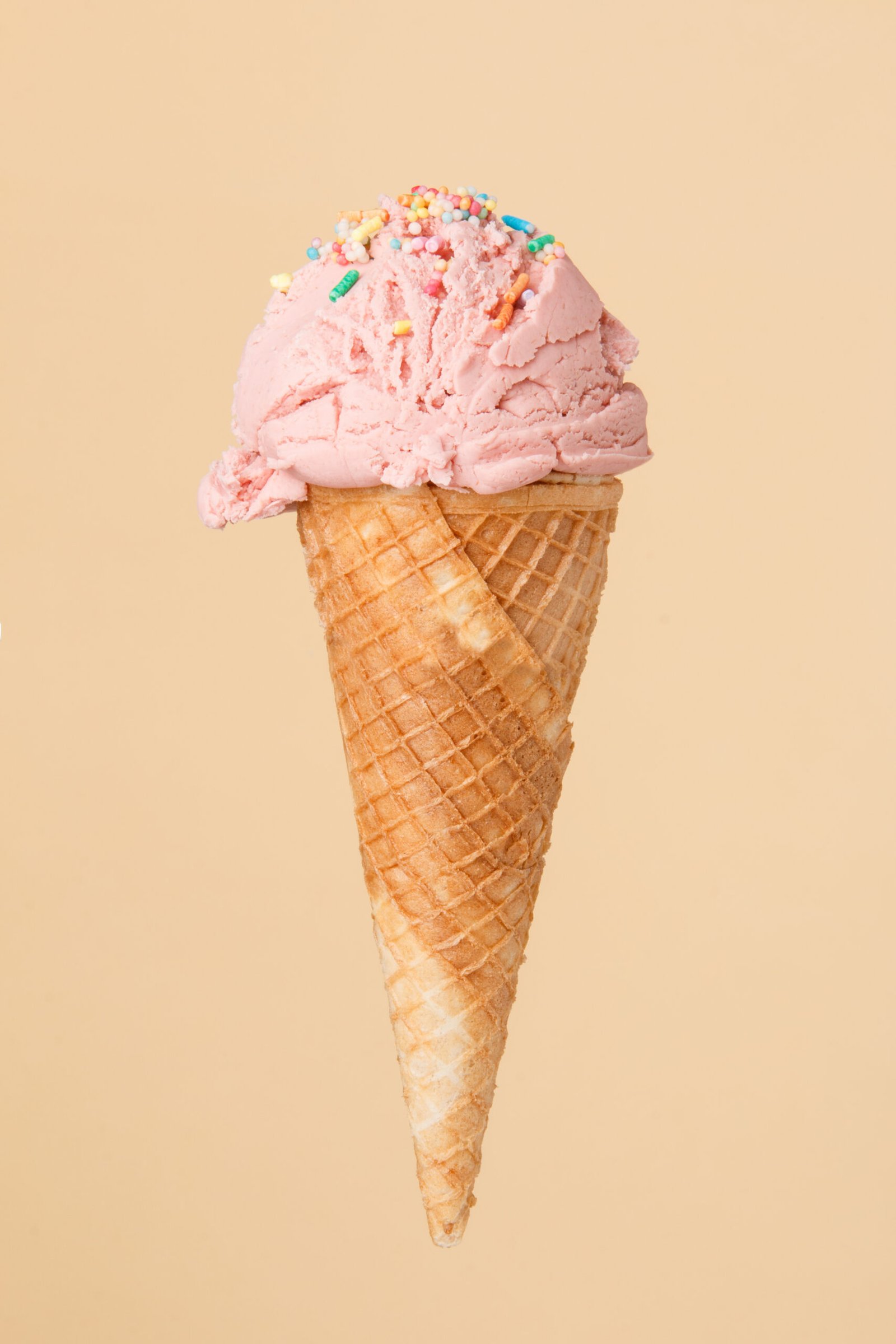 Cornet ice cream with a strawberry scoop on a colorful backgroun