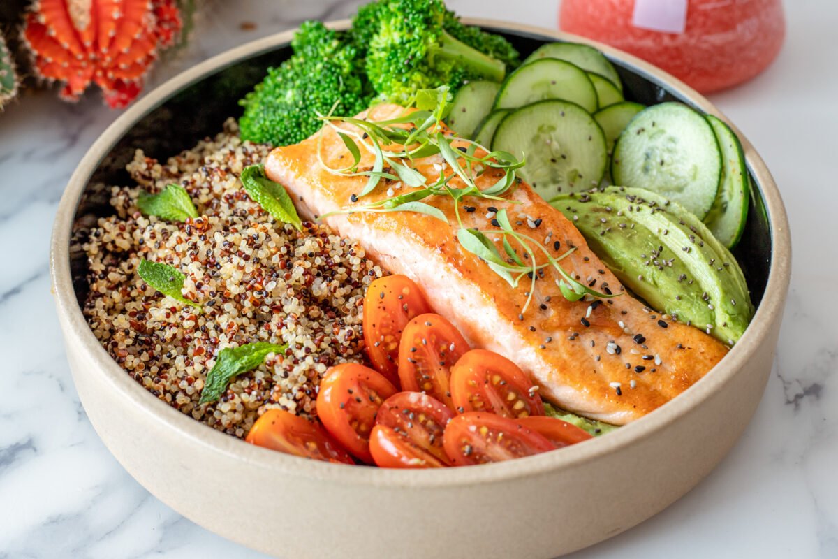 Plate of salmon with quinoa and raw vegetables