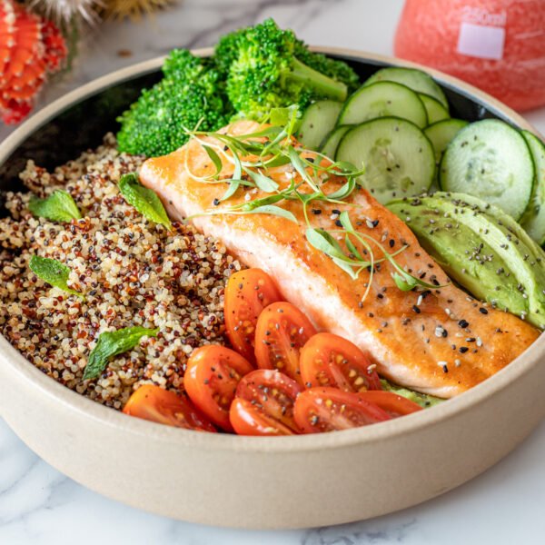 Plate of salmon with quinoa and raw vegetables