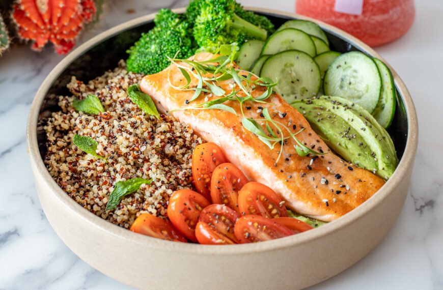 Plate of salmon with quinoa and raw vegetables