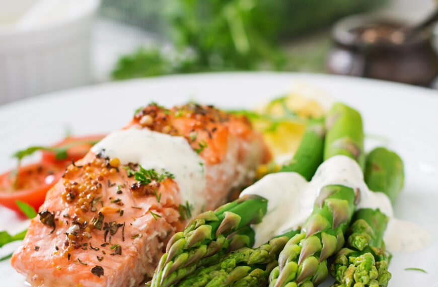 Baked salmon garnished with asparagus and tomatoes with herbs