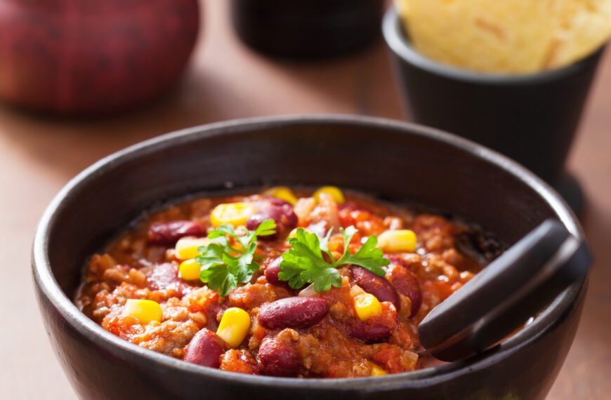 Mexican chili con carne in black plate with ingredients