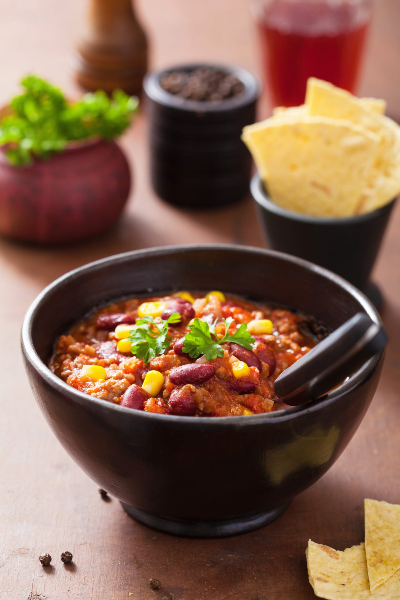 Mexican chili con carne in black plate with ingredients