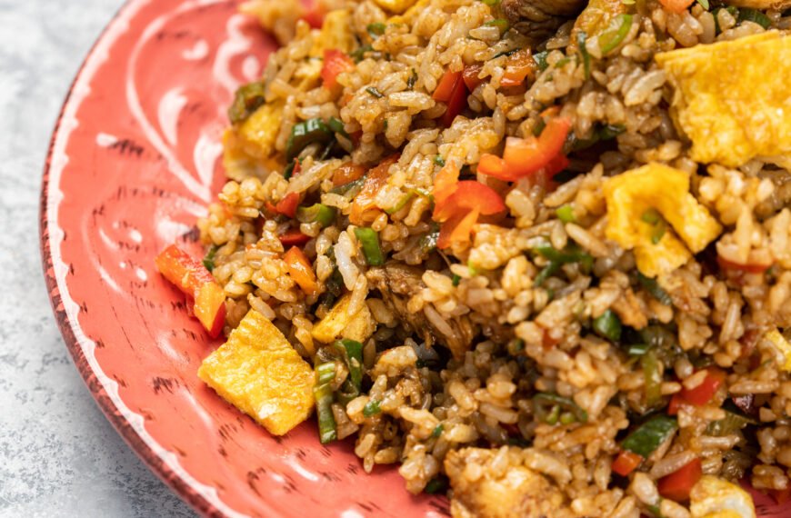 Closeup of delicious cooked rice with vegetables and sauce in a plate on the table