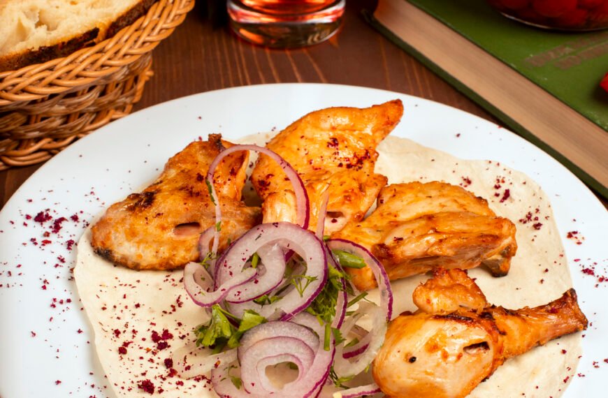 Grilled chicken wings kebab served with composto onion vegetable salad herbs white plate