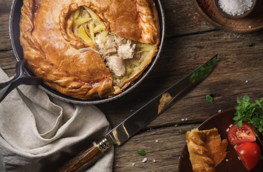 Pie on stainless steel bowl beside black handled knife