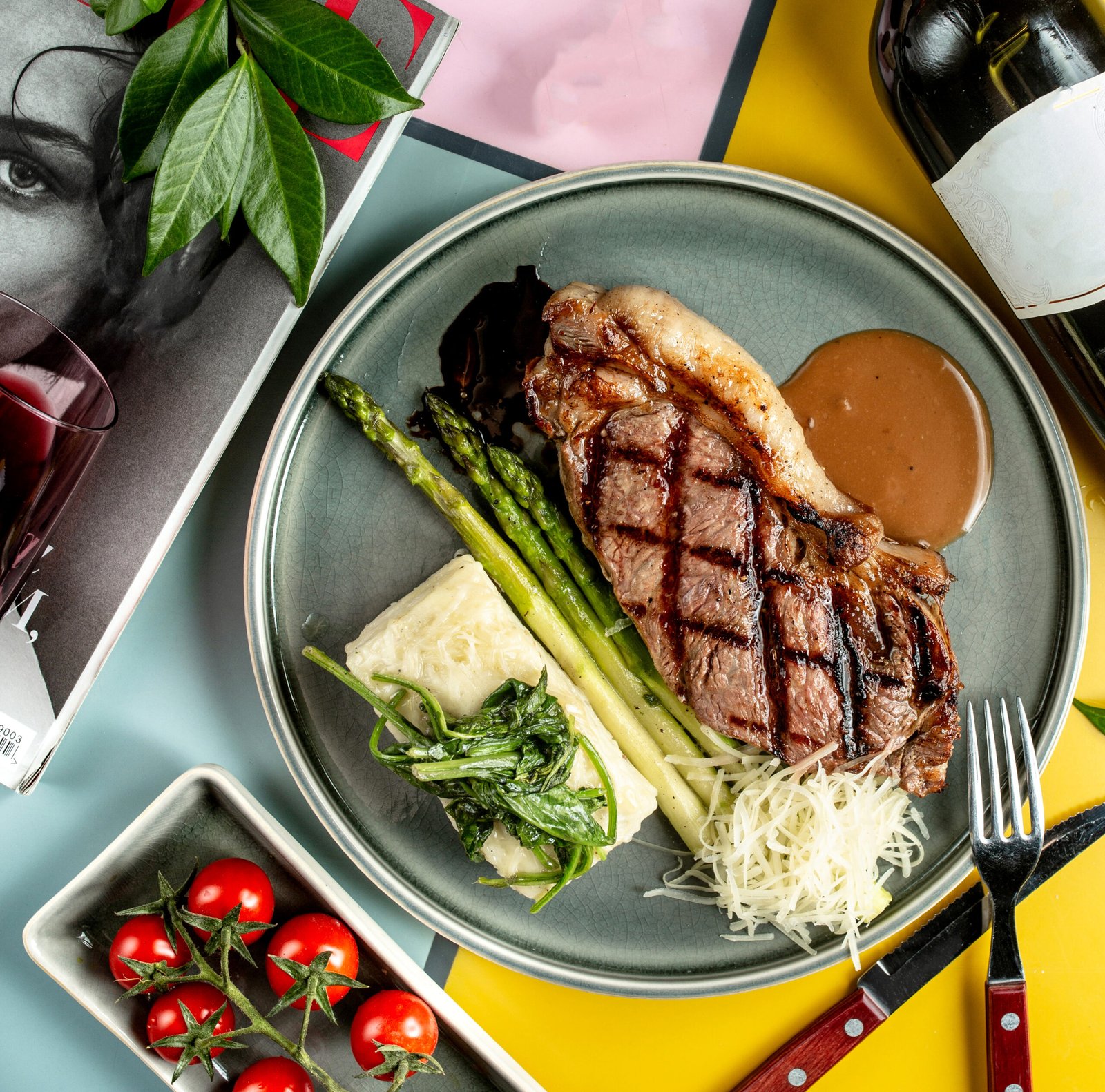 Top view of beef steak served with boiled asparagus spinach and sauce